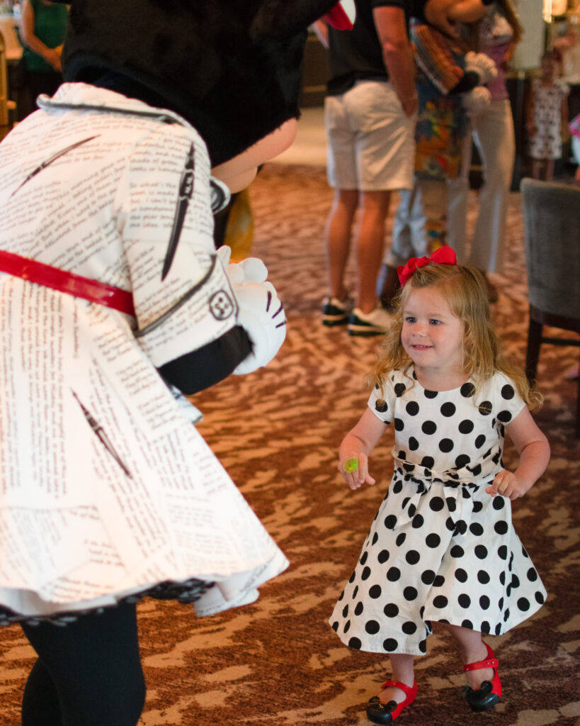 little girl interacts with minnie mouse at topolino's terrace at walt disney world 