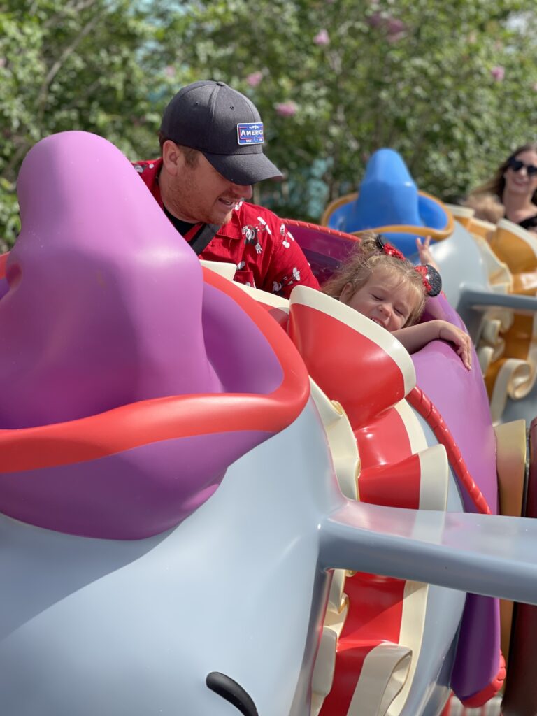 father and daughter ride dumbo at walt disney world 